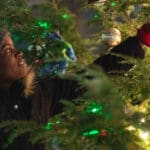 Student hanging ornament on Christmas tree